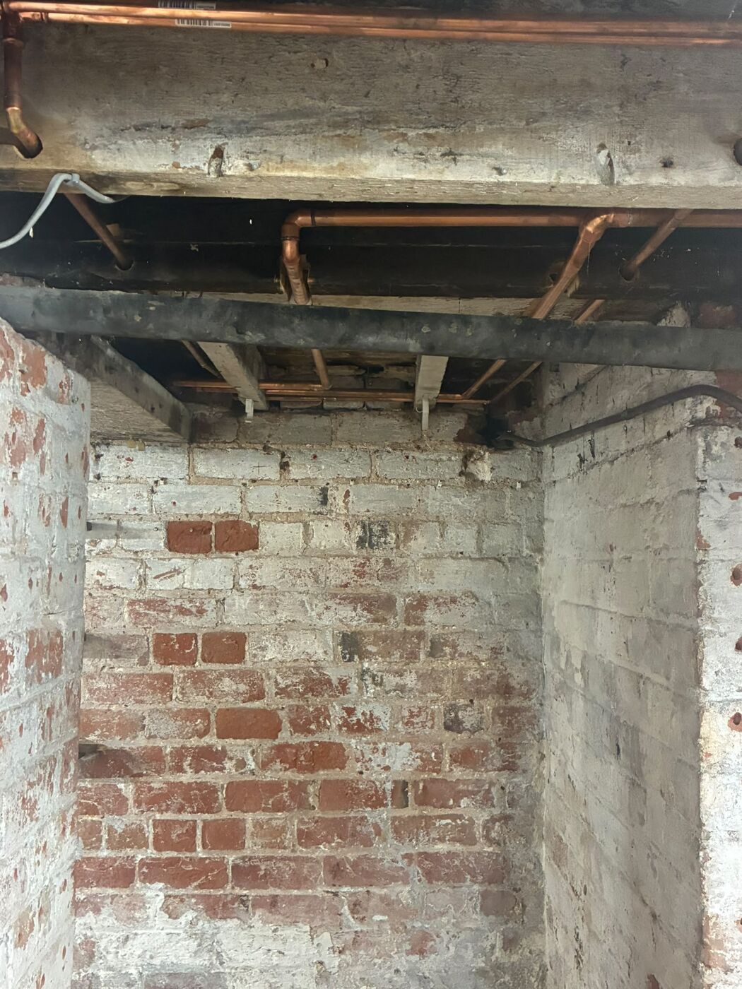 Copper pipe work routed through joists in a cellar ceiling