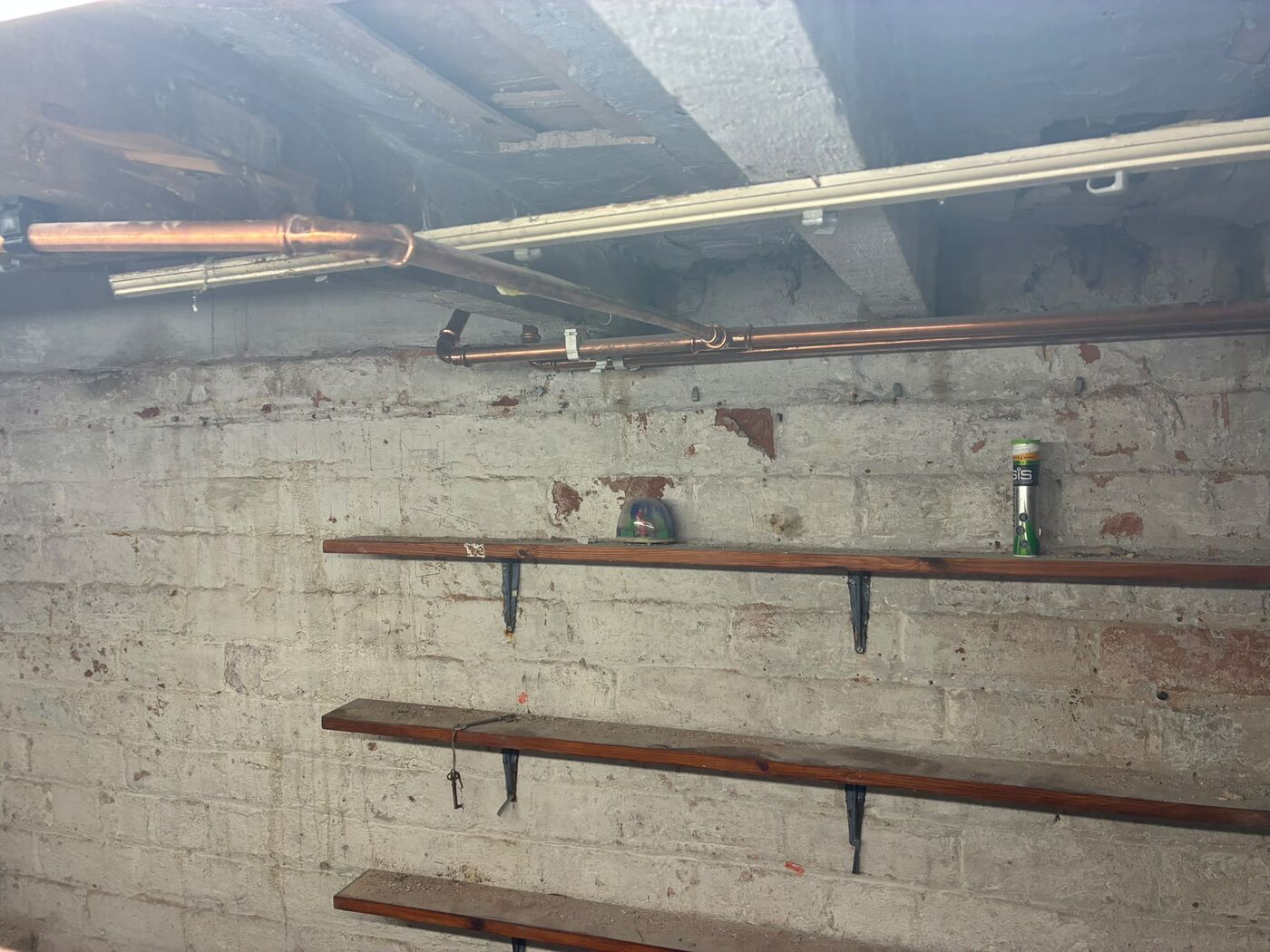 Copper pipe work bracketed along a brick wall with supports fitted