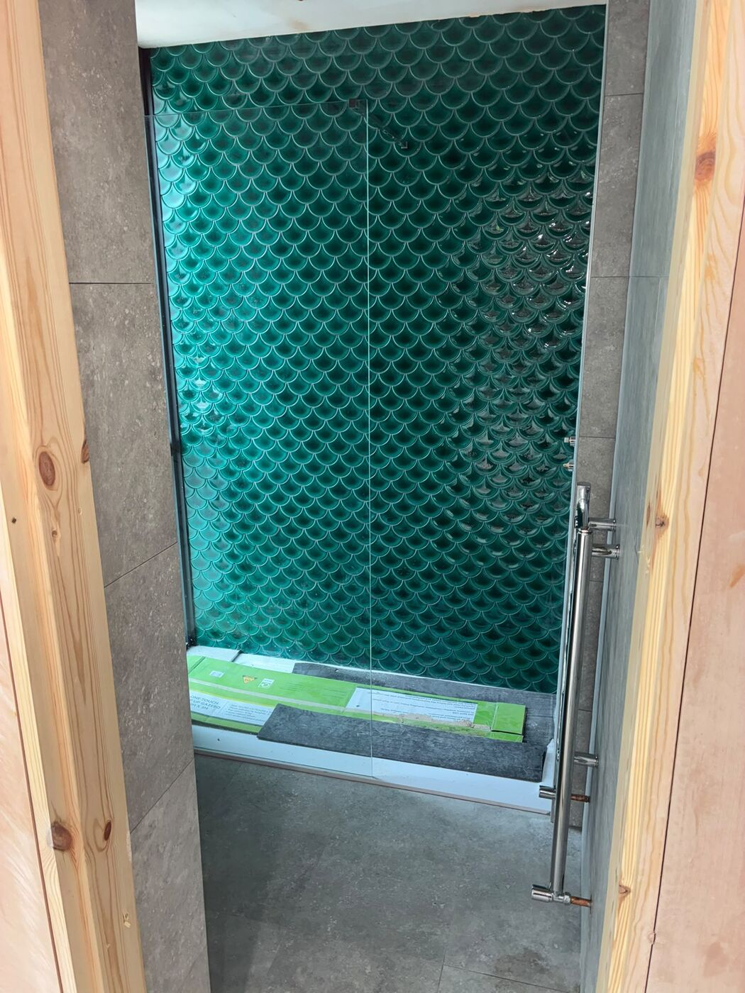 Finished tiled shower enclosure with green feature tiles and glass screen
