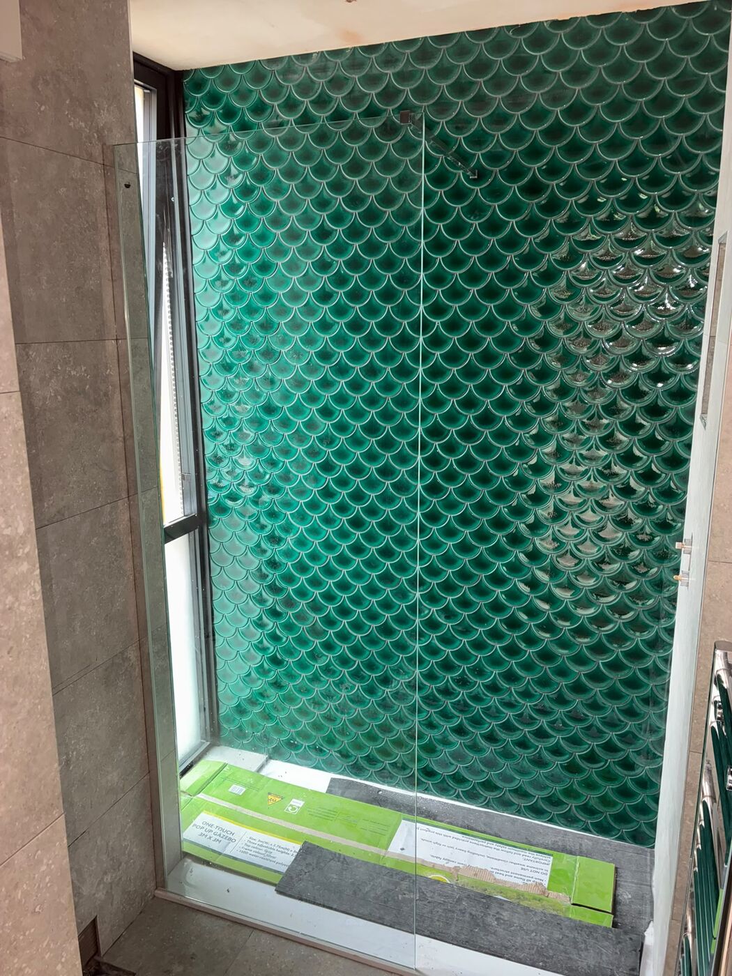 Green feature tiled shower wall with timber frame and glass door