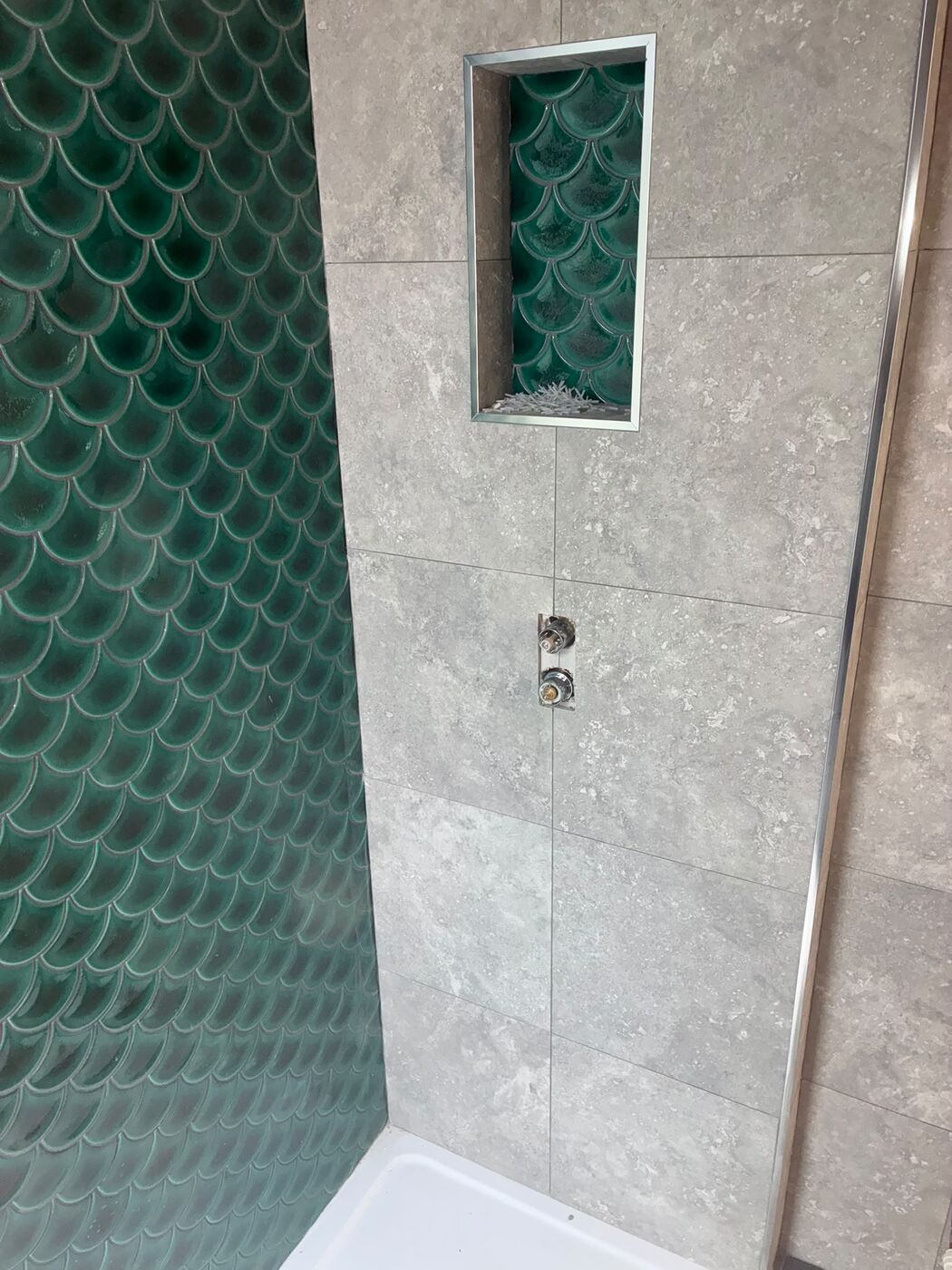Tiled shower with a recessed niche and green feature tiles, plumbing fitted by PureFlo